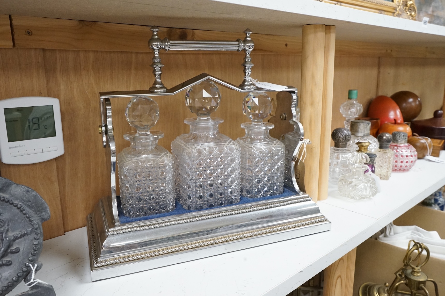 A Betjemann’s Patent chrome plated Tantalus, patent 42244, with key, complete with hobnail decanters, 38.5cm wide